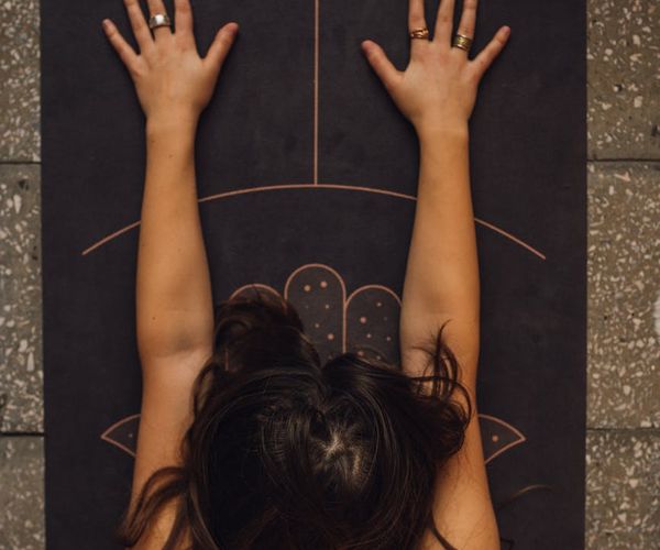 Person trying a simple yoga stretch for beginners on a mat.