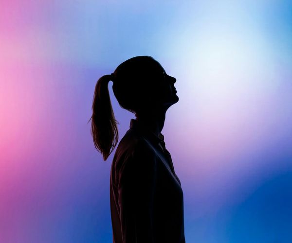 Silhouette of a person in a yoga balance pose against a gradient background.